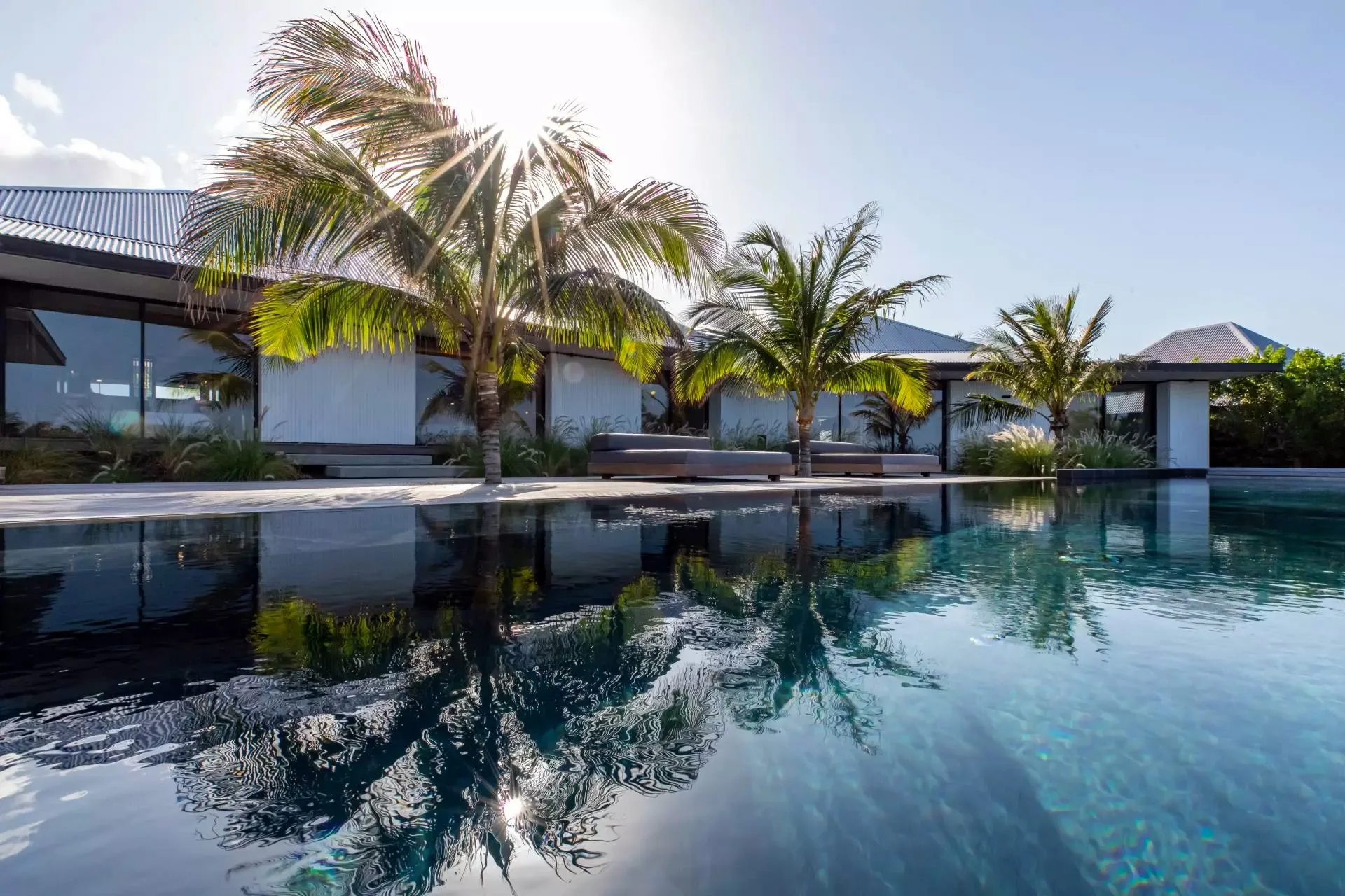 Hillside villa terrace at Pointe Milou in St Barth, with infinity pool and ocean view at sunset